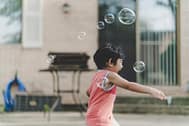 kid playing with soap bubbles 